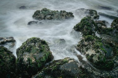 Sahil hareketi, kayanın tepesine çarpan beyaz dalga, uzun süreli görüntü dalgası