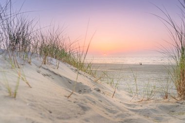 Günbatımında kum tepeleri olan kuzey deniz manzarası