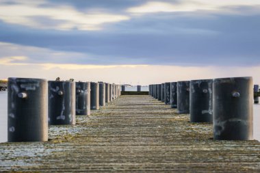 Son akşam ışığı altında ahşap iskelede demirli kalınlar.