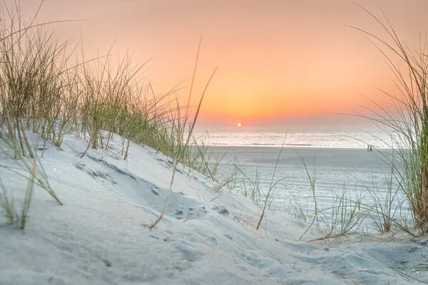 Günbatımında kum tepeleri olan kuzey deniz manzarası