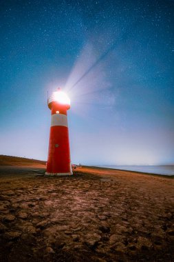 Deniz feneri ve Samanyolu Kuzey Denizi 'nin yukarısındaki Zeeland' deki deniz çukurunda Hollanda, Westkapelle yakınlarında.