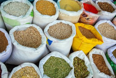 bezelye, fasulye, humus, mısır ve diğer topaklar poşetlerde.