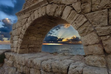 Eski su kemeri Romalılar tarafından Caesarea İsrail 'de gün batımında gökyüzüne karşı inşa edildi.