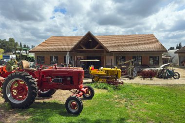 Eski tekerlekli traktör, kırsal alanın arka planına karşı restore edildi.