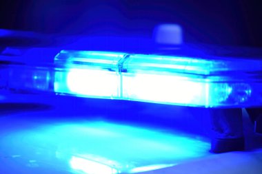 Gece sokakta mavi ışığı olan polis arabası, seçici odaklı.