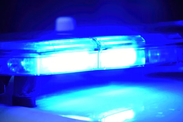 stock image Police car with blue light on the street at night, selective focus