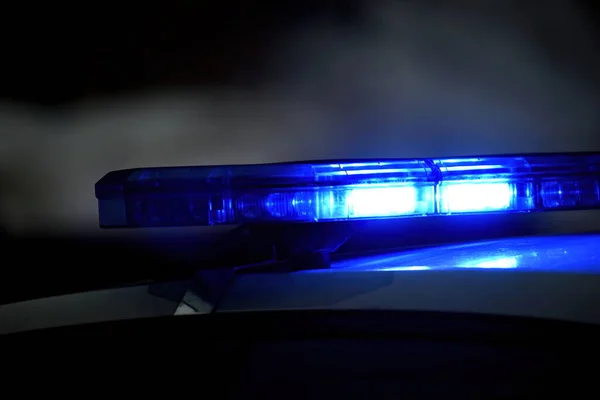 夜の路上で青の光を持つ警察の車 選択的フォーカス ストック写真