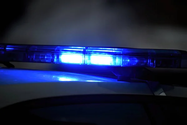 夜の路上で青の光を持つ警察の車 選択的フォーカス ストック画像