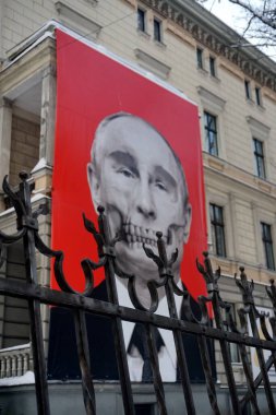 Riga, Latvia, december 14, 2022: Red big banner with Putin's skull hung at Medicine History Museum in front of Russian embassy                               