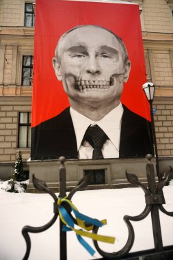Riga, Latvia, december 14, 2022: Red big banner with Putin's skull hung at Medicine History Museum in front of Russian embassy                               