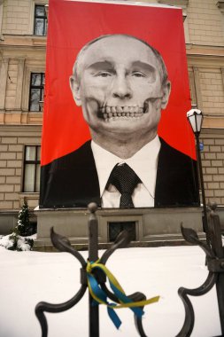 Riga, Latvia, december 14, 2022: Red big banner with Putin's skull hung at Medicine History Museum in front of Russian embassy                               