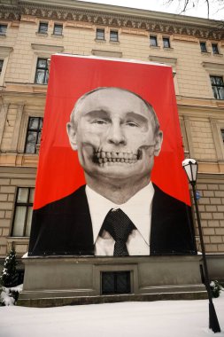 Riga, Latvia, december 14, 2022: Red big banner with Putin's skull hung at Medicine History Museum in front of Russian embassy                               