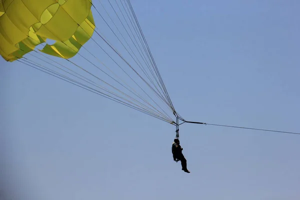 在布德瓦海滩附近的蓝天中漫步 黄色的降落伞和人们在一起 — 图库照片