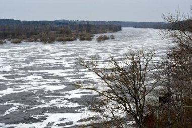 Daugava Nehri çok yüksek su seviyesine sahip, suyun yüzeyinde beyaz köpük var. Yüksek su seviyesi Letonya 'nın Aizkraukle kentindeki Paviu Hidroelektrik İstasyonu' ndan geliyor.