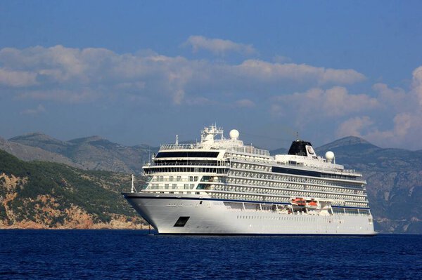 Bright blue water and white cruise liner in the Adriatic Sea, mountains in the background, Dubrovnik, Croatia
