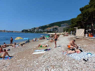 Budva, Karadağ - 19 Haziran 2023: Budva sahilinde yaz boyunca güneşlenen ve dinlenen insanlar.