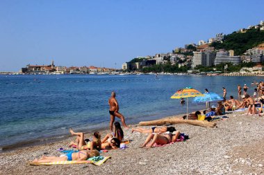 Budva, Karadağ - 19 Haziran 2023: Budva sahilinde yaz boyunca güneşlenen ve dinlenen insanlar.