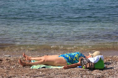 Budva, Karadağ - 19 Haziran 2023: Budva sahilinde yaz boyunca güneşlenen ve dinlenen insanlar.