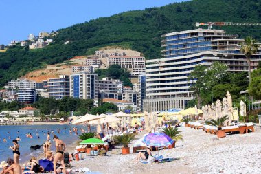 Budva, Karadağ - 19 Haziran 2023: Budva sahilinde yaz boyunca güneşlenen ve dinlenen insanlar.