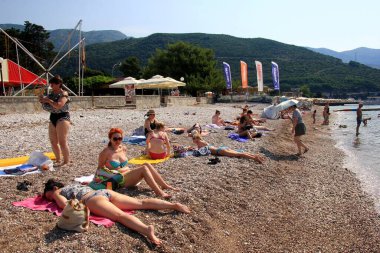 Budva, Karadağ - 19 Haziran 2023: Budva sahilinde yaz boyunca güneşlenen ve dinlenen insanlar.