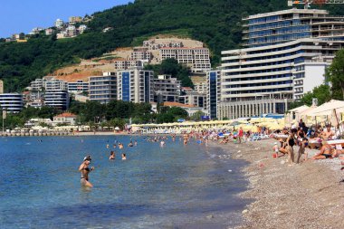 Budva, Karadağ - 19 Haziran 2023: Budva sahilinde yaz boyunca güneşlenen ve dinlenen insanlar.