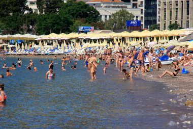 Budva, Karadağ - 19 Haziran 2023: Budva sahilinde yaz boyunca güneşlenen ve dinlenen insanlar.