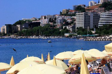 Budva, Karadağ - 19 Haziran 2023: Budva sahilinde yaz boyunca güneşlenen ve dinlenen insanlar.