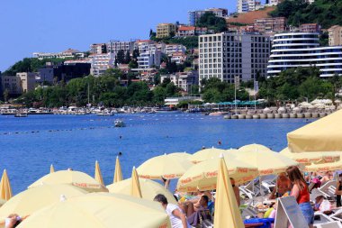 Budva, Karadağ - 19 Haziran 2023: Budva sahilinde yaz boyunca güneşlenen ve dinlenen insanlar.