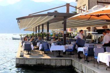 Perast - Karadağ, 20 Haziran 2023: Perast, Karadağ 'da şehir manzarası, sokak, evler, turistler ve tekneler.