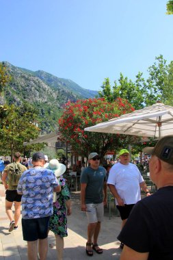 Kotor, Karadağ - 19 Haziran 2023: Turistler eski kent surları boyunca yürüyorlar. Kotor Limanı - Karadağ