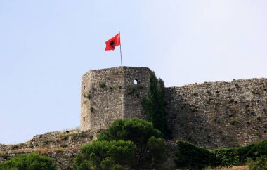 Shkoder, Arnavutluk - 24 Haziran 2023: Arnavutluk ulusal bayrağı eski Şkodra kalesi Rozafa Kalesi 'nin kulesinde dalgalanıyor