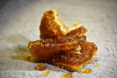 Gri keten kumaşa bal sürülmüş bal parçaları, bal işleme illüstrasyonu