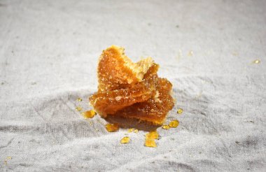 Gri keten kumaşa bal sürülmüş bal parçaları, bal işleme illüstrasyonu