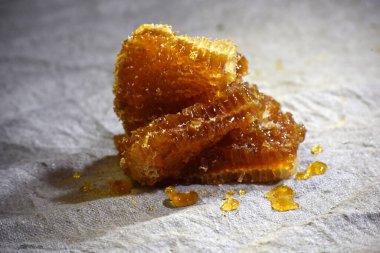 Gri keten kumaşa bal sürülmüş bal parçaları, bal işleme illüstrasyonu