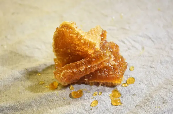 Gri keten kumaşa bal sürülmüş bal parçaları, bal işleme illüstrasyonu