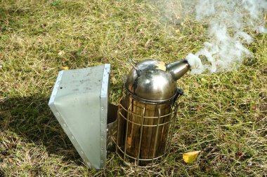   Bir arı yetiştiricisinin dumanlı sigara ve yangın söndürme ekipmanlarını kapatın.                             