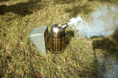   Bir arı yetiştiricisinin dumanlı sigara ve yangın söndürme ekipmanlarını kapatın.                             