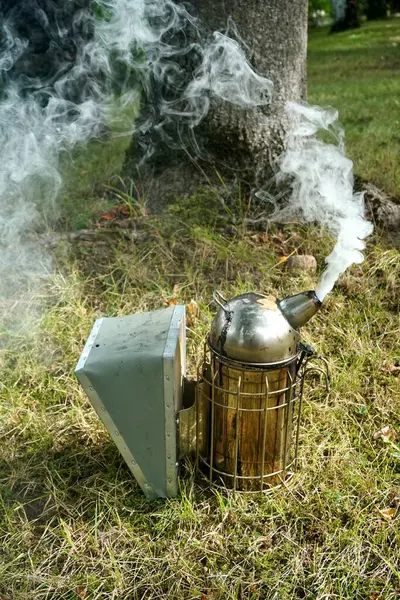 stock image   Close up of a beekeepers smoking equipment with smoke and fire coming out of the nozzle                             