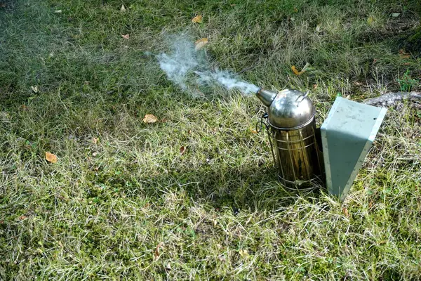 stock image   Close up of a beekeepers smoking equipment with smoke and fire coming out of the nozzle                             