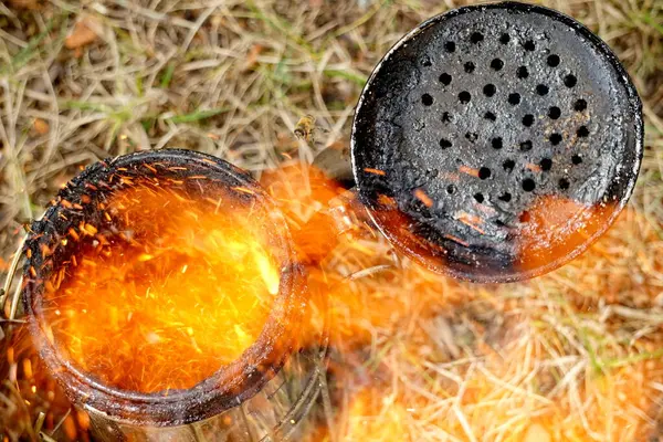 stock image   Close up of a beekeepers smoking equipment with smoke and fire coming out of the nozzle                             