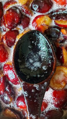 Şekerli eriklerden reçel yapmak. Erik reçeli hazırlamak. Tatlı meyve arkaplanı