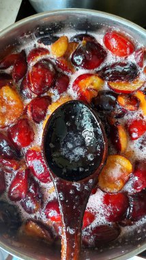 Şekerli eriklerden reçel yapmak. Erik reçeli hazırlamak. Tatlı meyve arkaplanı