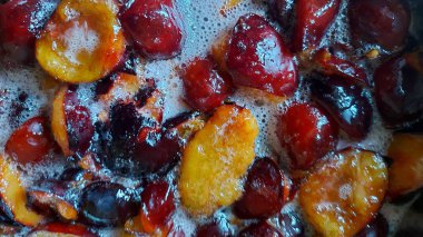 Şekerli eriklerden reçel yapmak. Erik reçeli hazırlamak. Tatlı meyve arkaplanı