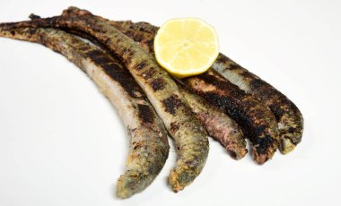 Fried lampreys on a plate and in a dish. Latvian lamprey recipes clipart