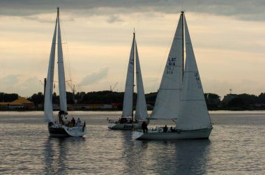 Riga, Letonya 05 Ağustos 2005: Riga, Daugava Nehri 'nde yelken yarışı. Yatlar akşam ışığında suyun üzerinde.