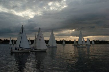 Riga, Latvia 05 August, 2005: Sailing competition in Riga, river Daugava. Yachts on the water in the evening light clipart