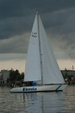 Riga, Latvia 05 August, 2005: Sailing competition in Riga, river Daugava. Yachts on the water in the evening light clipart