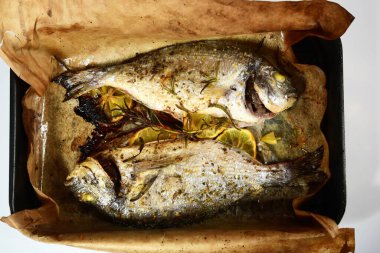 İki kızarmış dorada, ızgara sebzeli, limonlu ve baharatlı. Dorado tarifleri, beyaz arkaplan