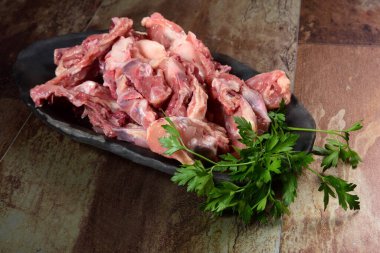 Siyah kil tabakta etli tavuk kemikleri, kahverengi taş arka plan. Tavuk çorbası seçimi