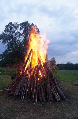              Letonya 'da yaz arifesinde büyük bir şenlik ateşi yanıyor. Kırsal alanda akşam vakti parlak şenlik ateşi yanıyor.                  